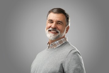 Wall Mural - Portrait of happy casual mature man smiling, senior age man with gray hair, Isolated on gray background