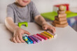 © illustrissima - A three-year-old boy plays with crayons, plasticine and a construction set. The concept of early development and sensory perception. Finger games in kindergarten
