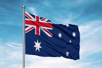 Wall Mural - Australia national flag cloth fabric waving on beautiful sky Background.