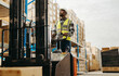 © Jacob Lund - Man in a reflective jacket driving a forklift in a warehouse