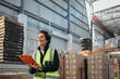 © Jacob Lund - Mature warehouse manager smiling while holding a file