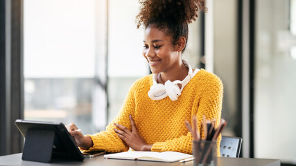 Wall Mural - African american student woman in sweater watching e-learning an