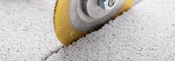 Metal saw, end mill or drill bit with diamond coating makes hole in concrete slab. Industry and construction.