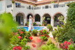 © Caia Image - Senior woman walking along swimming pool in summer villa garden