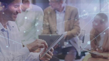 Canvas Print - Animation of network of connections over caucasian man using digital tablet at office