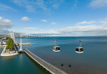 Canvas Print - Telecabine Lisboa at Park of Nations. Vasco da Gama tower and Bridge in Lisbon. Cable car in the modern district of Lisbon over the Tagus river