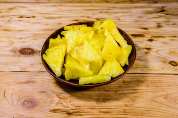 Wall Mural - Ceramic plate with sliced pineapple on wooden table