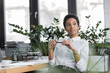 © LIGHTFIELD STUDIOS - positive and dreamy african american businesswoman holding pen and looking away while sitting in office.
