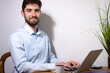 portrait d'un jeune employé de bureau ou homme d'affaires qui travaille devant son ordinateur portable