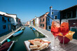 Spritz for two with snacks in Burano with the canal in the background