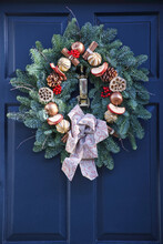 A Decorative Christmas Wreath On A Blue House Door; London, England