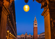 View of St Mark's Campanile and St Mark's Cathedral with lights illuminating the  Piazza San Marco in Veneto at dusk; Venice, Italy