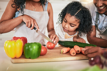 Wall Mural - Family, cutting vegetables and cooking together, learning chef skill with parents and child in kitchen. Nutrition, healthy food and organic with people teaching and learn to cook at home with bonding