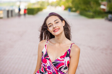 Portrait of a young beautiful brunette  girl in summer park