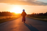 Fototapeta  - Kid Riding In The Sunset