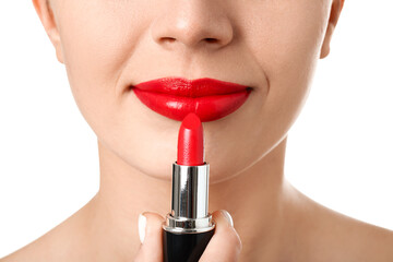 Woman applying red lipstick on white background, closeup