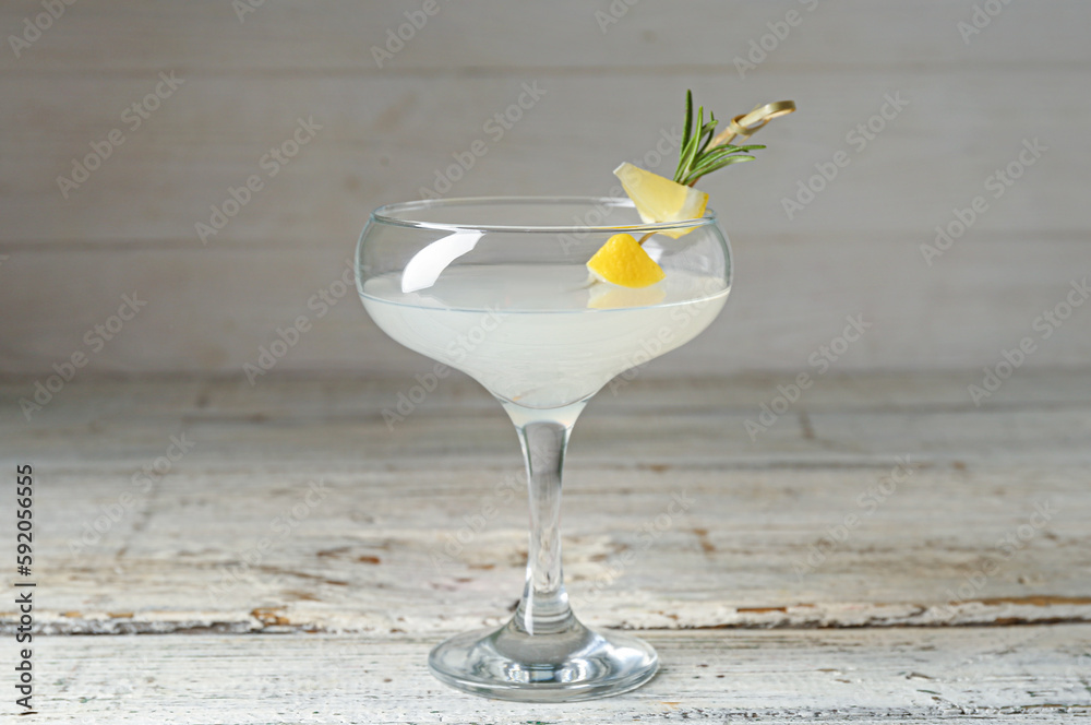Glass of martini with lemon on wooden table