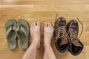 Wall Mural -  Some barefoot male feet hesitating between sandals or boots