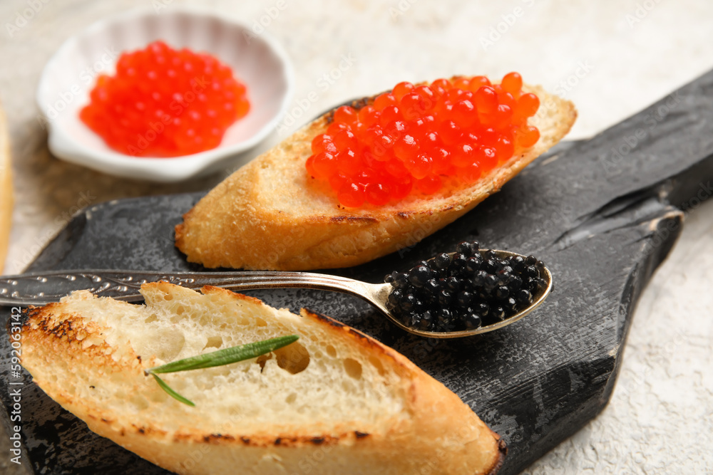 Tasty bruschettas with red and black caviar on grunge background