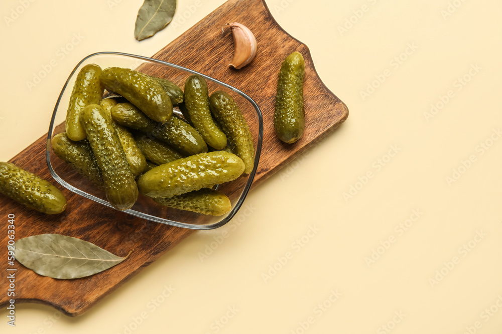 Bowl with tasty fermented cucumbers on beige background