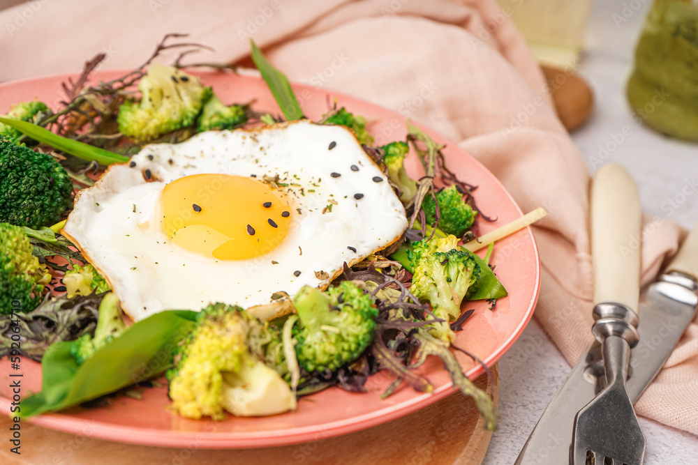 Plate with tasty fried egg and salad, closeup