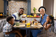© wavebreak3 - Cheerful african american parents and children talking while having breakfast at dining table