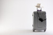 Suitcase with straw hat, sunglasses and camera on white background with copy space