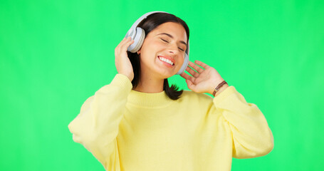 Canvas Print - Face, green screen and woman with headphones, listen and movement on a studio background. Portrait, female dancer and person with headset, streaming music and excitement with stress relief and relax