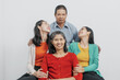 © NanSan - Happy anniversary day family of Elderly father and mother with old sister and young sister real people sitting together on sofa, Do activities together with love happily in the summer.