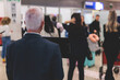 © tsuguliev - Meeting at the airport, person holding a placard card sign with welcome title text, greeting passenger on arrival, holding a name plate to receive a traveler, arrival area at international terminal