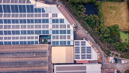 Wall Mural - A large solar cell roof on an industrial building Generating electricity for the plant during daytime according to policies and measures to reduce global warming by taking high-angle shots from drones