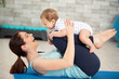 mother makes postnatal exercises with her baby