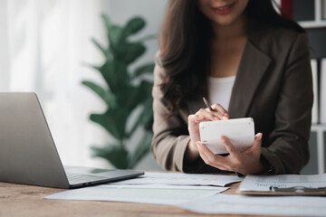 Wall Mural - Businessman using a calculator to calculate numbers on a company's financial documents, she is analyzing historical financial data to plan how to grow the company. Financial concept.