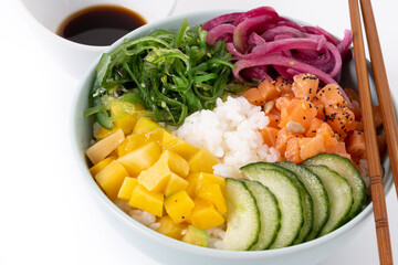 Wall Mural - Poke bowl with rice, salmon,cucumber,mango,onion,wakame salad, poppy seeds ands sunflowers seeds isolated on white background