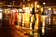 Man walks in the dark in the rain at the station forecourt in Essen, Germany