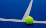 Fototapeta Sport - close-up view of a ball on the lines of a blue paddle tennis court, racket sports concept