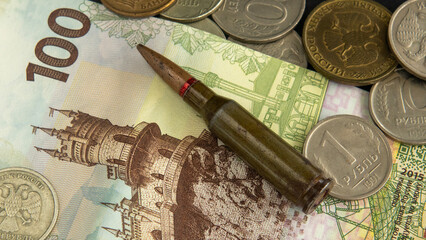 Bullet lies on Russian banknote among coins, symbol of Crimea, Russia's war, occupation of Ukraine, translation: 