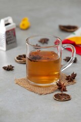 Sticker - Vertical shot of a mug with star anise (Illicium verum) tea with seeds on a blurred background