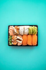 Poster - Platter of salmon sushi roll isolated on a blue background