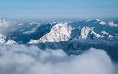 Wall Mural - Snowy mountains in the clouds. Beautiful landscape with snowy rocks