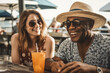 © ADDICTIVE STOCK - Generative AI illustration of positive multiracial couple in sunglasses and summer clothes smiling happily while sitting at wooden table with glass of refreshing beverage during vacation on beach