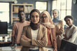 © ADDICTIVE STOCK - AI generated image of young female businesswoman standing arms crossed and looking at camera with diverse colleagues in office