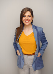 Poster - Portrait of smiling woman in blue suit and yellow shirt.