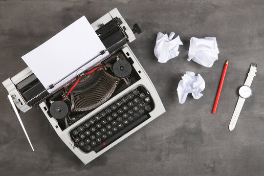 vintage typewriter on the table with blank paper on the desk - concept for writing, journalism, blogging