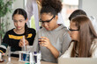 © winnievinzence - Diversity group of students in protective eyeglasses in science class doing chemical experiment in laboratory. Teacher watching girl mixing chemistry in test tube. learning and education concept