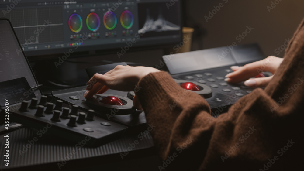 Female editor works in studio, uses digital color grading control panel ...