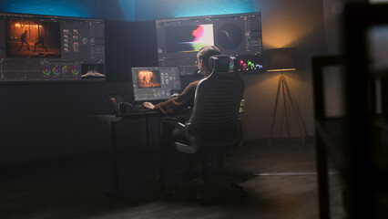 Fototapete - Female film editor or colorist does color grading on computer in modern studio. Big monitors with RGB colour correction graphic bar and program interface on the wall. Video post production. Handheld.