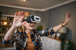 © Miljan Živković - Woman mature senior female at home enjoy virtual reality VR headset