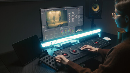 Fototapete - Female editor uses color grading control panel, edits video, makes movie color correction on computer and tablet in studio. Film footage and RGB wheels on monitor. Big screens with program interface.