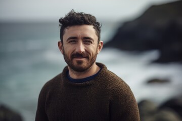 Sticker - Portrait of a handsome bearded man standing in front of the ocean